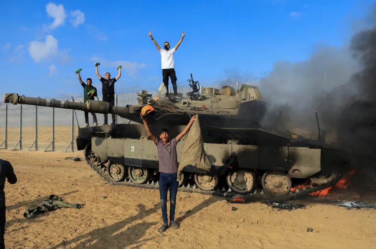 7 октября 2023 года. Горящий израильский танк. Палестинцы на израильской стороне границы Израиля и сектора Газа. Фото aljazeera.com.
