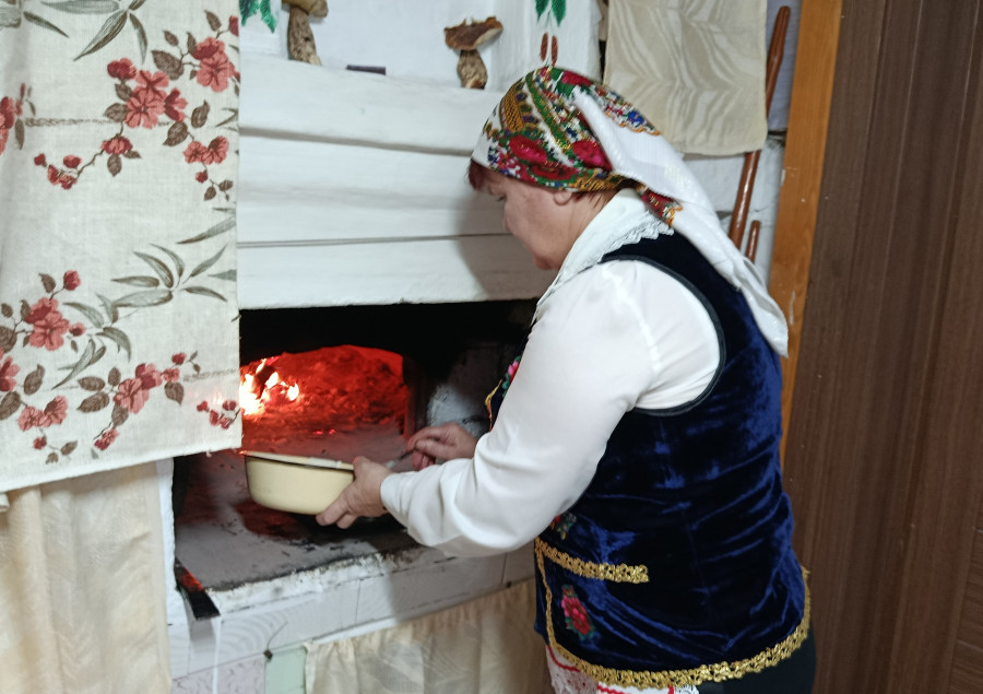  Снежань 2025 г. Галіна Васільеўна Гембіцкая гатуе бліны ў печы.