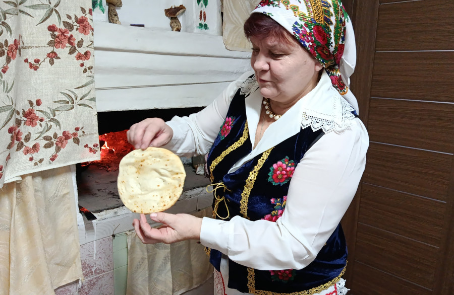 Снежань 2025 г. Галіна Васільеўна Гембіцкая гатуе бліны ў печы.
